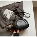 Chic black soft leather bucket bag with gold studs and a brown plush monkey charm - Black
