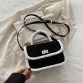 Fashionable black suede crossbody bag with white shearling trim and gold twist lock - Black