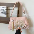 Elegant pink silk shoulder bag with traditional flower embroidery and a lotus tassel - Pink