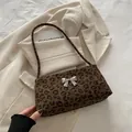 Fashionable leopard print shoulder bag featuring a metallic silver bow accent - Black