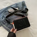 Bolso tipo cámara chic negro y naranja con correa ancha de lona a rayas y logo - Negro