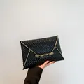 Elegant black envelope clutch bag with scale texture and gold metal clasp - Black