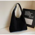 Large black faux shearling tote bag with leather wide shoulder strap in minimalist setting - Black