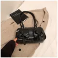 Chic black underarm bag featuring dual front pockets and satin ribbon bows accent - Black