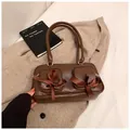 Dark brown underarm bag featuring ribbon bows and functional double front pockets - Coffee