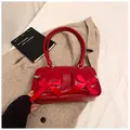 Elegant red shoulder bag with silk bows and dual pockets on soft beige wool coat - Red