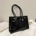Minimalist black glossy leather tote bag with gold metal buckles and slim straps - Black