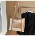 Detail of a beige tote bag with brown straps and a front zipper pocket on a hanger - Light Khaki