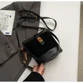 Sac seau noir avec texture pelucheuse et fermoir doré sur un blazer gris - Noir Avec Pendentif Lapin