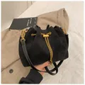 Detail der schwarzen matten Wildleder-Eimertasche mit Goldkette und Kordelzug - Schwarz