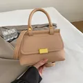 Sac bandoulière élégant en cuir abricot avec fermoir doré et poignée sur fond doux - Kaki