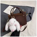 Dettaglio borsa a secchiello in finta pelle scamosciata marrone con finiture in peluche - Con Ciondolo / caffè