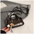 Borsa a mano Boston in pelle cerata marrone scuro con ciondolo baseball e tracolla - Caffè Con Ciondoli