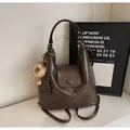 Brown vintage multi-way leather backpack with a cute plush lion charm and flap closure - Coffee With Rabbit Pendant