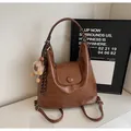 Brown faux leather tote bag with round flap and plush charm for shoulder or backpack use - Brown with Pendant