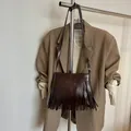 Dettaglio della borsa a tracolla in ecopelle marrone scuro con lunghe frange alla moda - PU Caffè