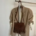 Detail der böhmischen dunkelbraunen Wildleder-Umhängetasche mit langen Fransen am Rack - Matt Kaffee