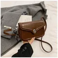 Classic brown leather crossbody bag with silver metal lock on a neutral bedding setup - Brown (With Pendant)