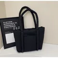 Schwarze gesteppte Puffer-Tasche mit gepolsterter Nylon-Textur und langen Schultergurten - Schwarz