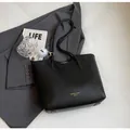 Minimalist black leather tote bag with gold logo and plush charm on grey blazer - With Ornament / Black
