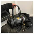 Glossy black bowling bag with vintage texture, gold hardware, and detachable strap - Black