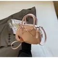 Detail of light pink mini handbag featuring a leather bow and fine lychee grain texture - Pink