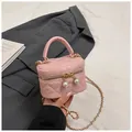 Close-up of pink quilted mini bag with pearl charms and metal chain strap details - Pink