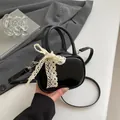 Μίνι μαύρη τσάντα από λουστρίνι με μια λεπτή λεπτομέρεια από λευκό δαντελένιο φιόγκο - Μαύρο