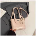 Close-up of pink quilted tote bag with pearl heart pendant and elegant metal lock detail - With Ornament / Pink