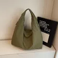 Olijfgroene oversized nylon draagtas met brede schouderband op marmeren ondergrond - Groen