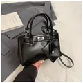 Chic black textured leather handbag with mini triangle pouch and silver turn-lock clasp - Black