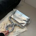 Borsa a tracolla argento con tracolla arricciata e finitura metallica su sfondo vintage - Argento