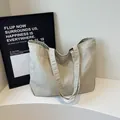 Minimalistische beige Canvas-Tragetasche mit langen Griffen für die Schulter im modernen Studio - Cremeweiß