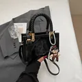 Glossy black square handbag with woven rope handle and cute pendant charm in 2025 style - Black