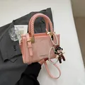 Pink minimalist crossbody square bag with woven handle and cute doll pendant charm - Pink