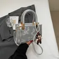 Silver mini square handbag with woven handle and pearl charm for crossbody wear - Silver
