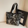 Minimalist black tote bag with white bamboo leaf print and sturdy shoulder straps - Black