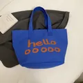 Sac fourre-tout en toile bleue avec lettrage orange hello et larges bandoulières - Bleu