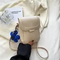 Minimalist beige PU leather crossbody phone bag with a blue flower charm accessory - Off White