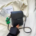 Minimalist black leather vertical phone bag with green flower charm and gold hardware - Black