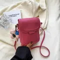 Mini crossbody phone bag in vibrant rose pink with cute blue smile and plush charm - Pink