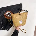 Brown woven straw bucket bag with long straps and cute capybara label detail - Brown