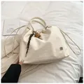 Chic beige drawstring bucket bag with floral metal logo and woven charm detail - With Baseball Pendant / White
