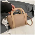 Borsa a mano kaki texture litchi con ciondolo gatto peluche e tracolla regolabile - cachi con ciondolo