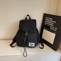 Minimalist black nylon backpack with flap closure and trendy street style woven label - Black
