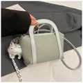 Borsa a secchiello verde chiaro motivo litchi con tracolla tessuta e ciondolo gatto - Verde con ciondolo
