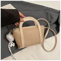 Borsa a secchiello bicolore beige e marrone effetto litchi con ciondolo morbido - Cachi Con Ciondolo