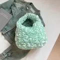 Chic mint green pleated handbag with satin finish and ruffled texture on denim jacket - Green