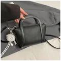 Borsa a secchiello nera in pelle martellata con dettagli argento e ciondolo peluche - nero con ciondolo