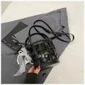 Dettaglio borsa a secchiello in pelle intrecciata nera con fodera e ciondolo di perle - Nero con Pendente